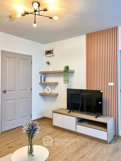 Modern living room with stylish decor and wooden accents, featuring a sleek TV stand and contemporary lighting.