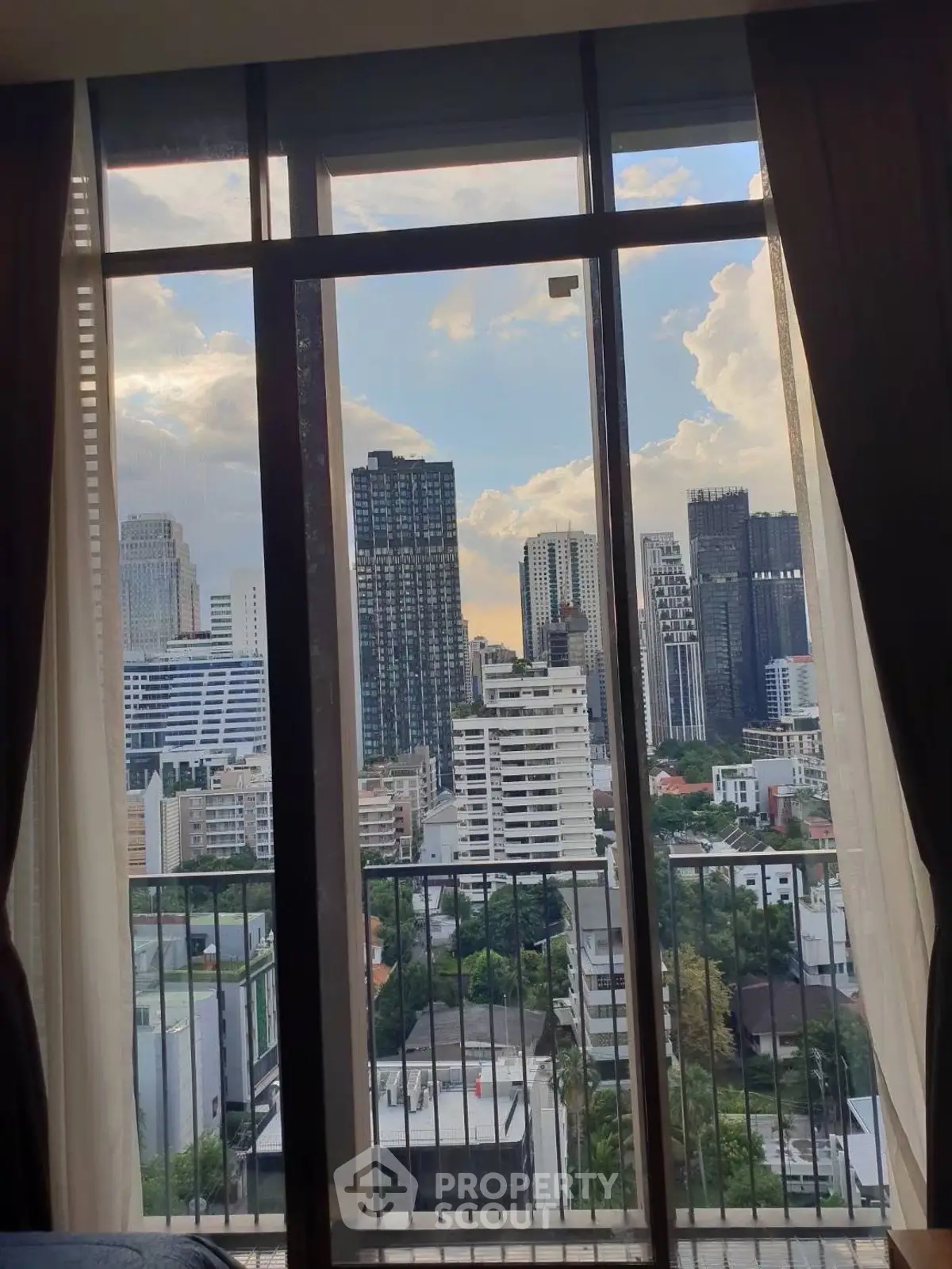 Stunning cityscape view from a high-rise apartment window, showcasing urban skyline and vibrant city life.