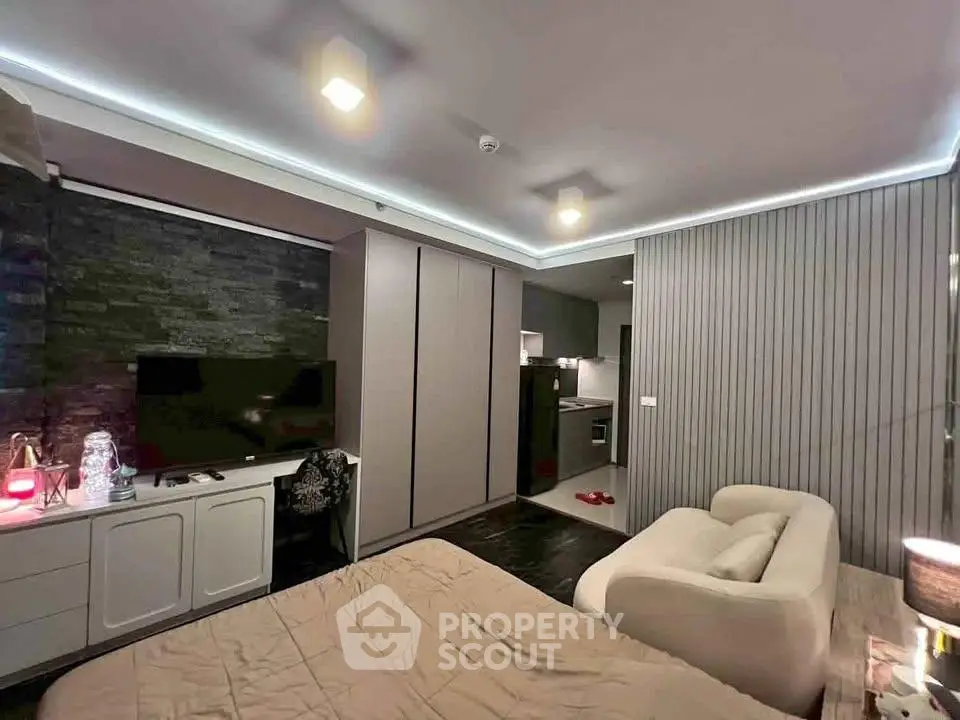 Modern studio apartment with sleek design and cozy ambiance, featuring a compact kitchen and stylish decor.
