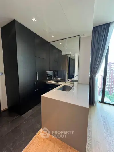Modern kitchen with sleek black cabinetry and large window view