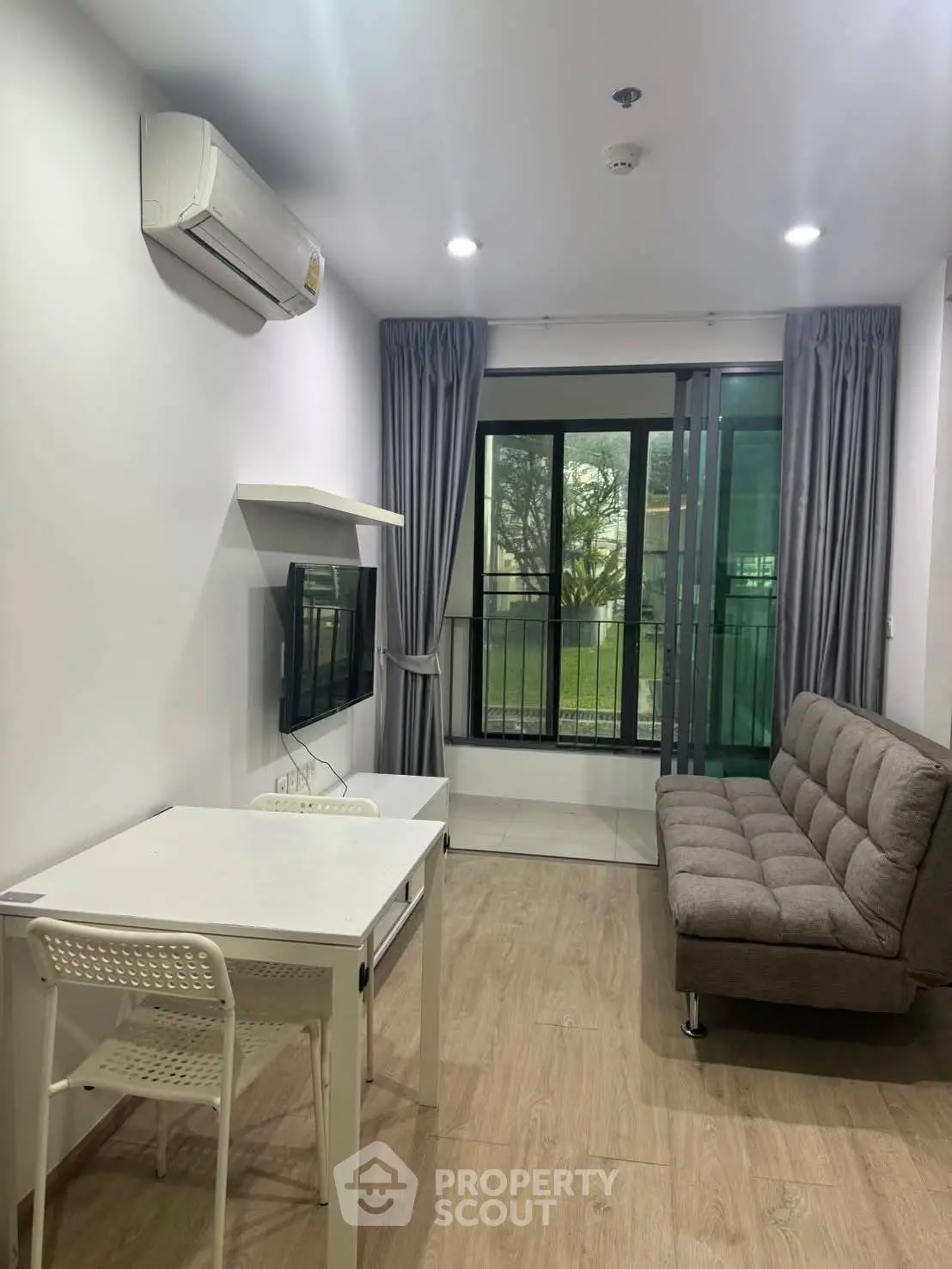 Modern living room with sleek furniture and balcony view in a stylish apartment.