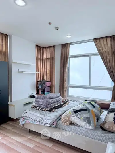 Modern bedroom with large windows and stylish decor in a cozy apartment.