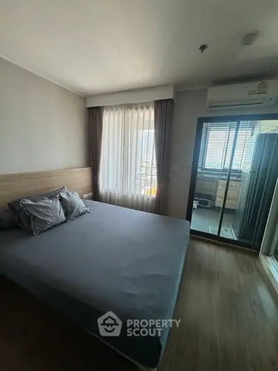Modern bedroom with large window and air conditioning, featuring sleek design and ample natural light.