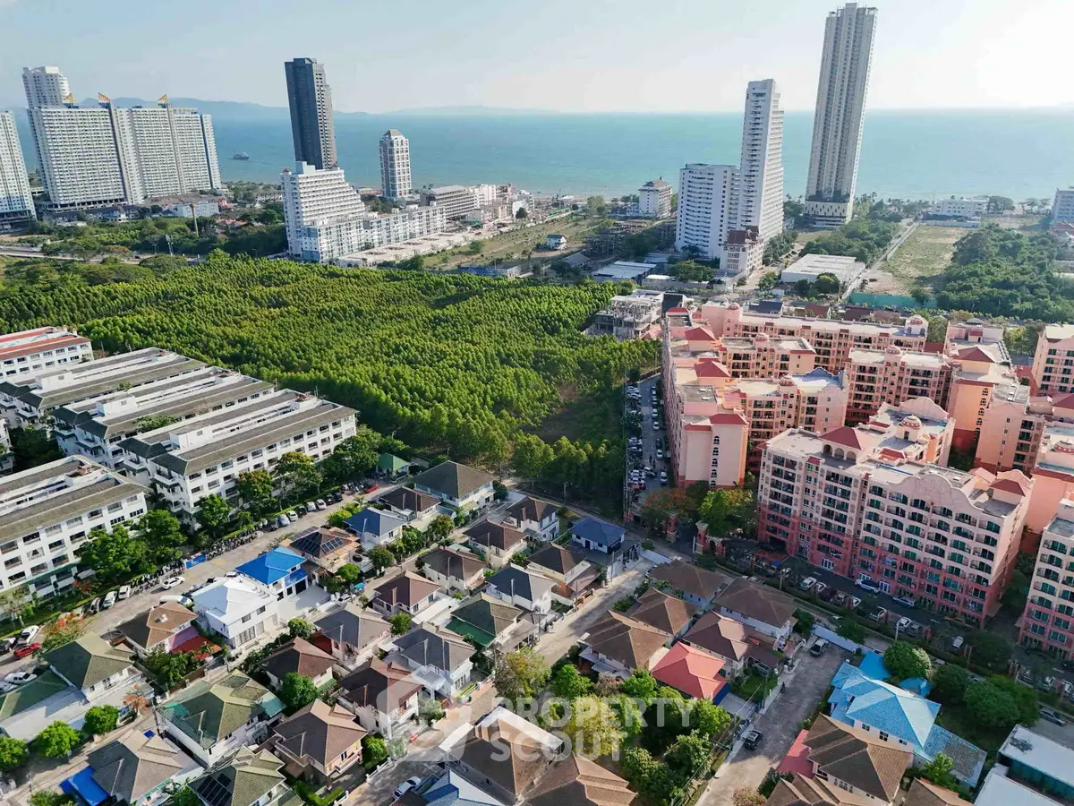 Aerial view of coastal cityscape with residential and high-rise buildings near the ocean.
