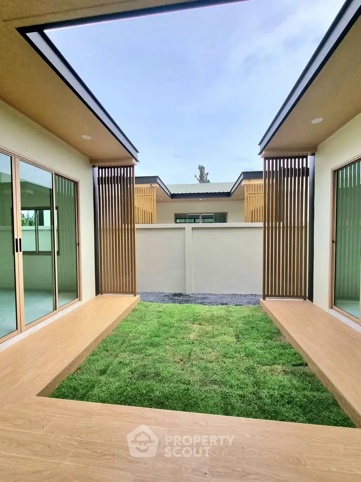 Modern courtyard with open sky view and wooden accents in contemporary home design.