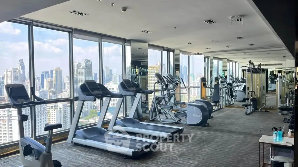 Luxurious high-rise gym with panoramic city views and modern fitness equipment.