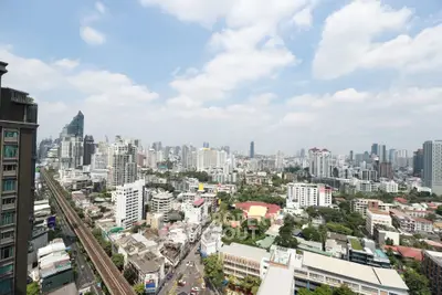 Stunning cityscape view from high-rise apartment balcony in vibrant urban area.
