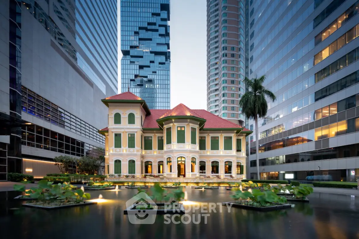 Stunning historic villa surrounded by modern skyscrapers, featuring a serene water garden in a bustling urban setting.