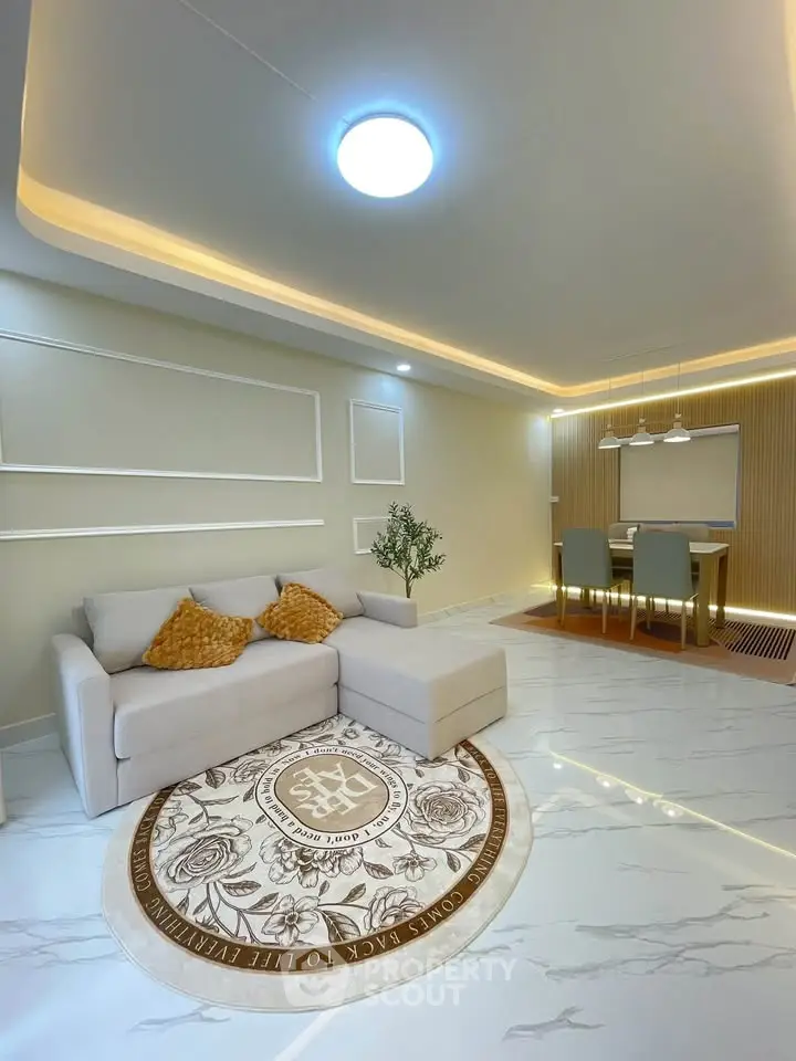 Modern living room with elegant lighting and stylish dining area, featuring a cozy sofa and decorative rug.