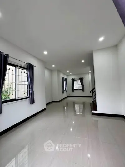 Spacious modern living room with large windows and sleek flooring