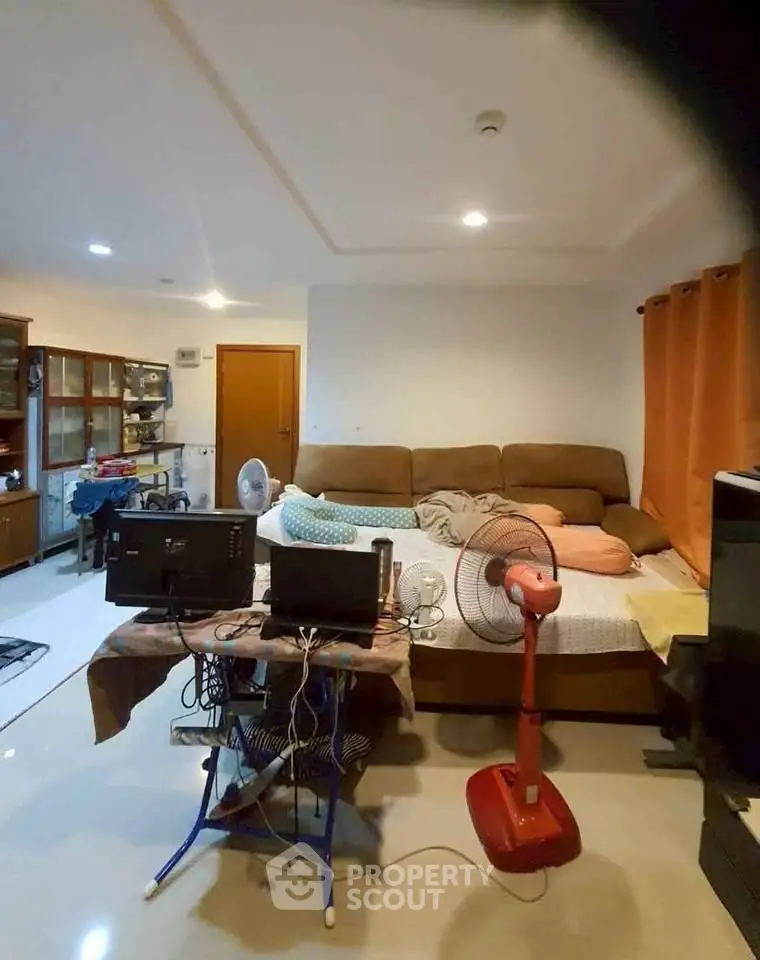 Cozy living room with sofa bed and home office setup, ideal for modern living.