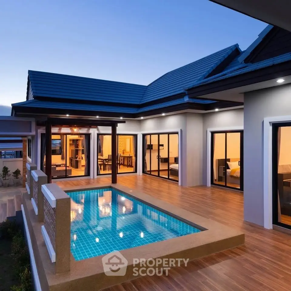 Luxurious modern villa with private pool and elegant outdoor lighting at dusk.