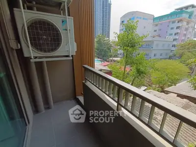 Charming balcony with city view and air conditioning unit, perfect for relaxing outdoors.