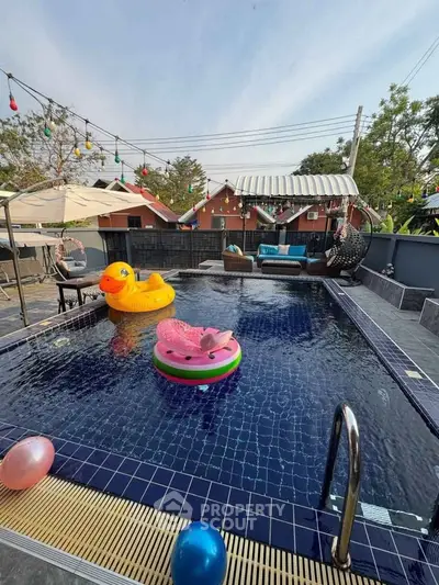 Charming outdoor pool area with playful inflatables and cozy seating, perfect for relaxation and entertainment.