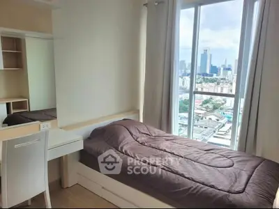 Cozy bedroom with city view, featuring a single bed and study desk, perfect for urban living.