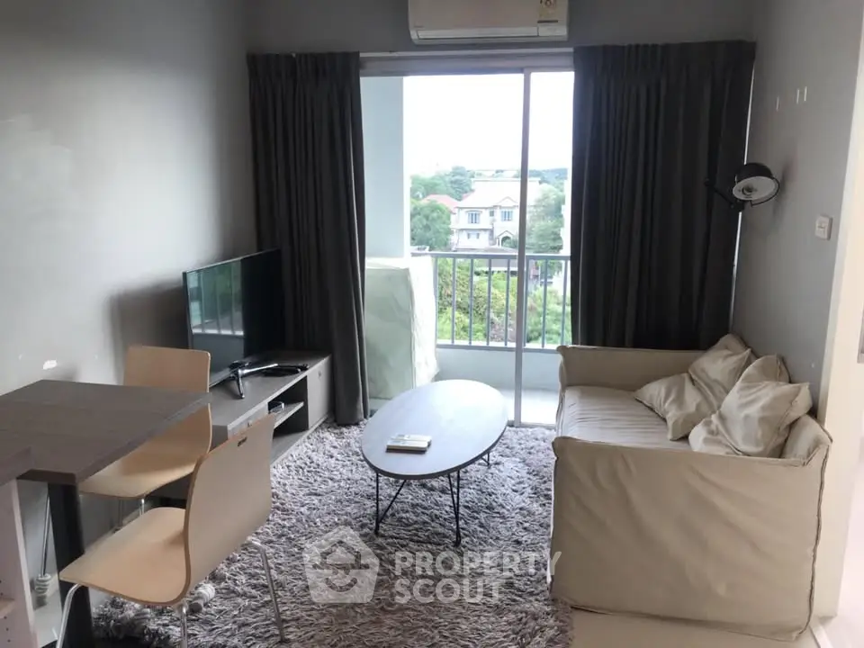 Cozy living room with modern furniture and balcony view in a stylish apartment.