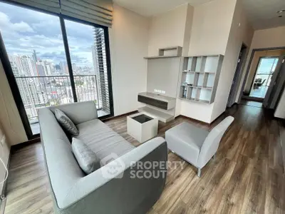 Modern living room with city view and stylish furniture in high-rise apartment.