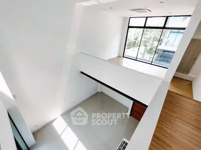 Spacious modern interior with high ceilings and large windows offering natural light.