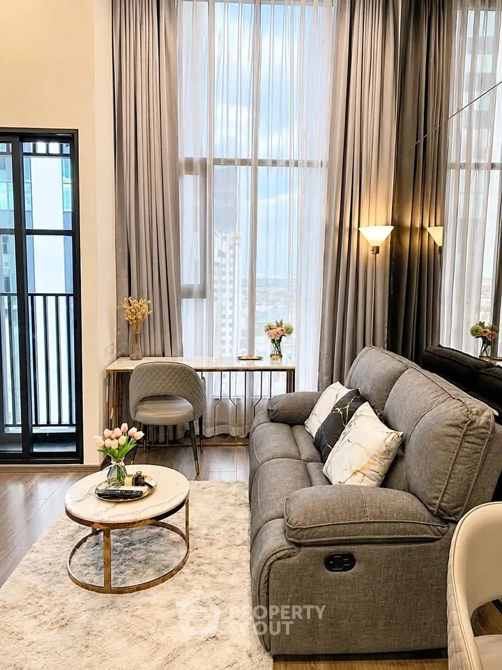 Elegant living room with high ceilings, plush sofa, and floor-to-ceiling windows offering stunning city views.