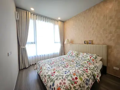 Cozy bedroom with floral bedding and soft lighting, perfect for relaxation.