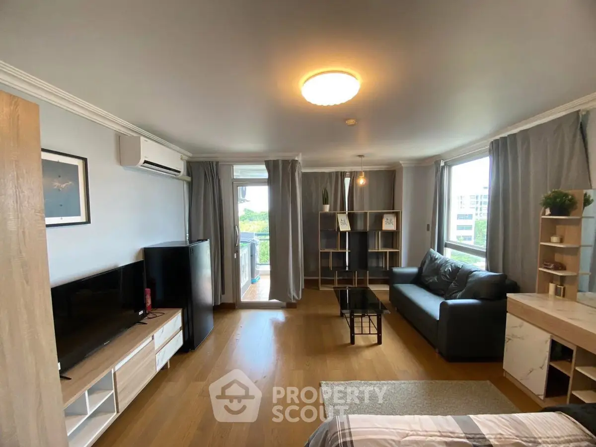 Spacious living room with modern decor and large windows offering natural light.
