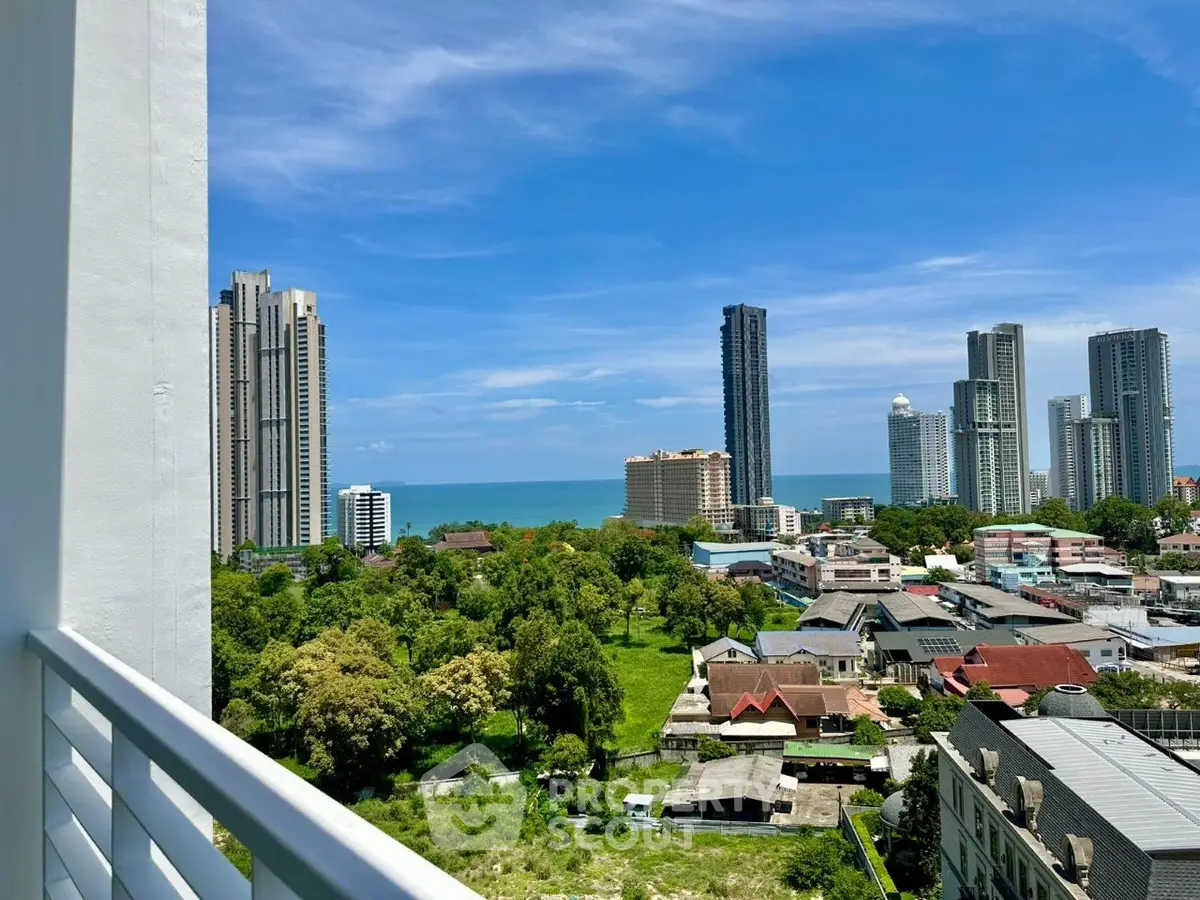 Stunning cityscape view from a high-rise balcony overlooking the ocean and skyline.