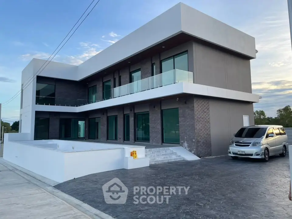 Modern two-story building with sleek design and spacious driveway, perfect for luxury living.