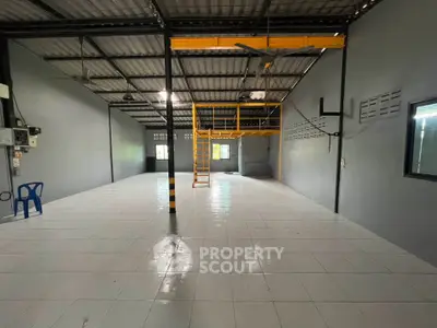 Spacious industrial warehouse with mezzanine and tiled flooring, ideal for storage or workshop use.