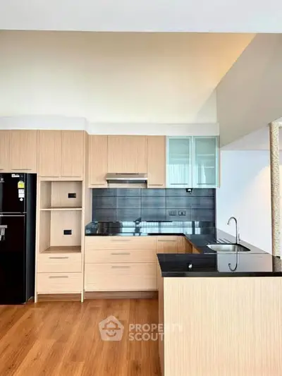 Modern kitchen with sleek wooden cabinetry and black countertops