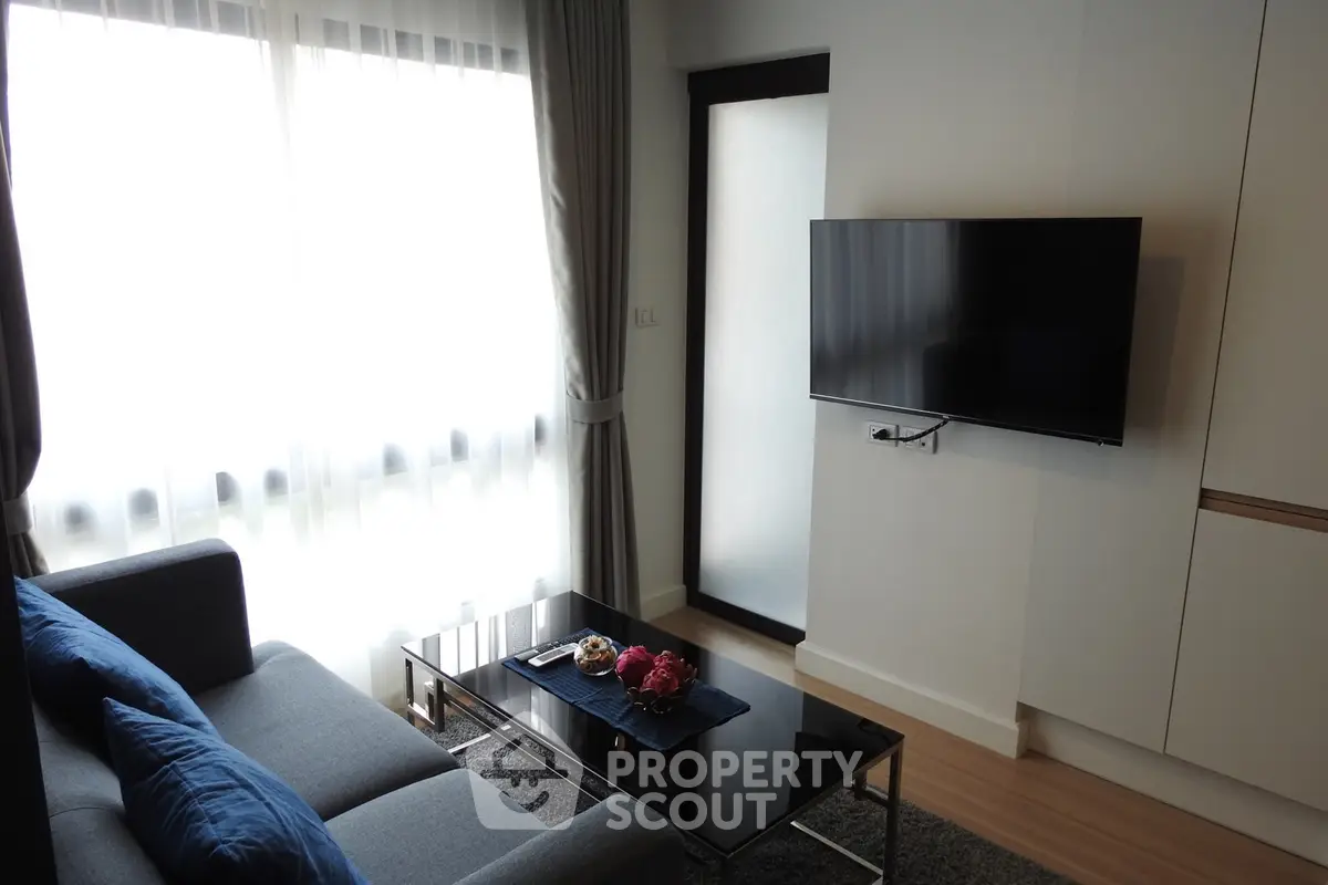 Modern living room with sleek TV setup and stylish furniture, perfect for urban living.