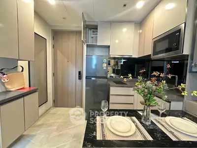 Modern kitchen with sleek cabinetry, built-in appliances, and elegant dining setup in a contemporary apartment.