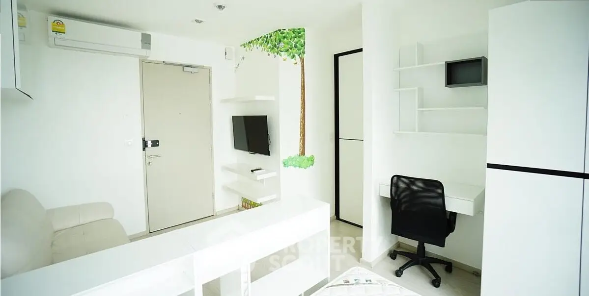 Modern minimalist living room with white furniture and wall-mounted TV