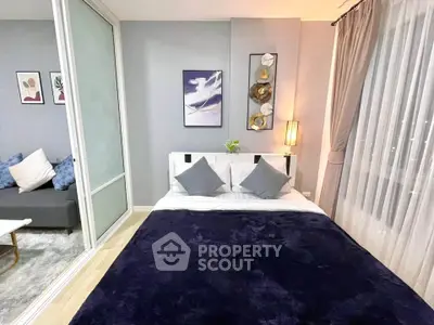 Modern bedroom with stylish decor and sliding glass doors leading to a cozy living area.