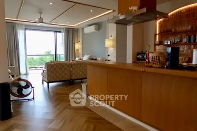 Spacious open-plan living room with modern kitchen and balcony view