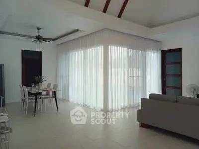 Spacious living room with elegant dining area and large windows