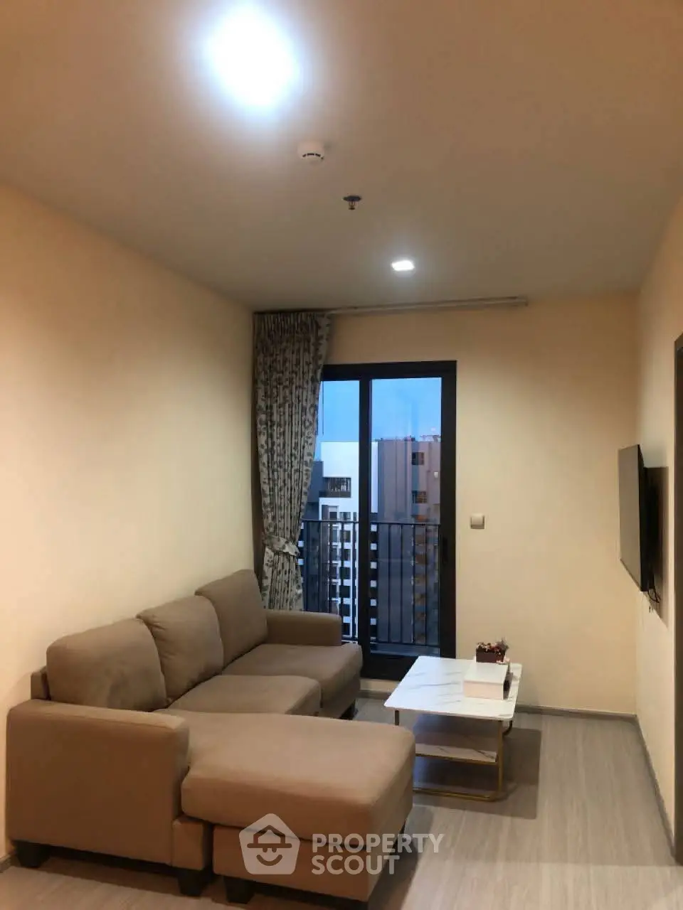 Cozy living room with modern sofa and balcony view in stylish apartment