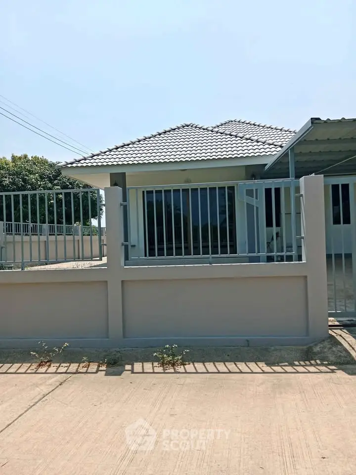 Charming single-story house with modern fence and tiled roof in a serene neighborhood.