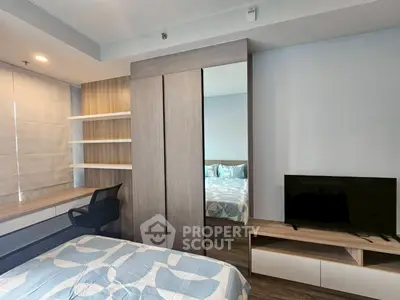 Modern bedroom with stylish decor, built-in shelves, and flat-screen TV for ultimate comfort.