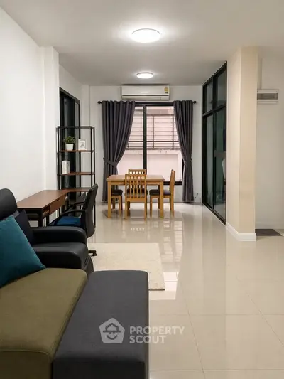 Spacious modern living room with dining area and large windows for natural light.