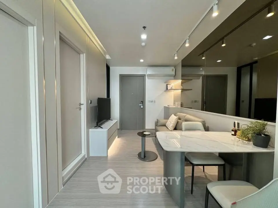 Modern living room with sleek design and open layout, featuring a cozy seating area and stylish decor.