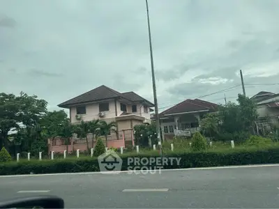 Charming suburban house with lush greenery and spacious front yard.