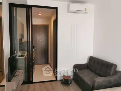 Modern living room with sleek glass partition and cozy sofa in stylish apartment.