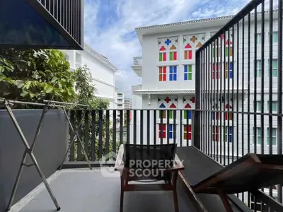 Charming balcony with modern railing and scenic view of colorful building facade.