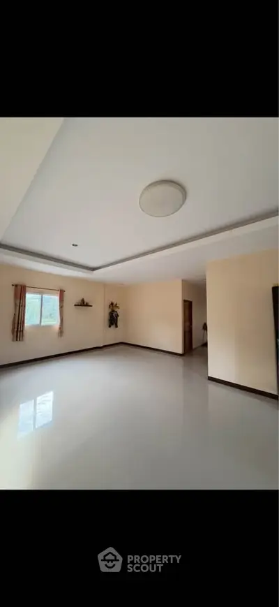 Spacious empty living room with large window and modern ceiling design