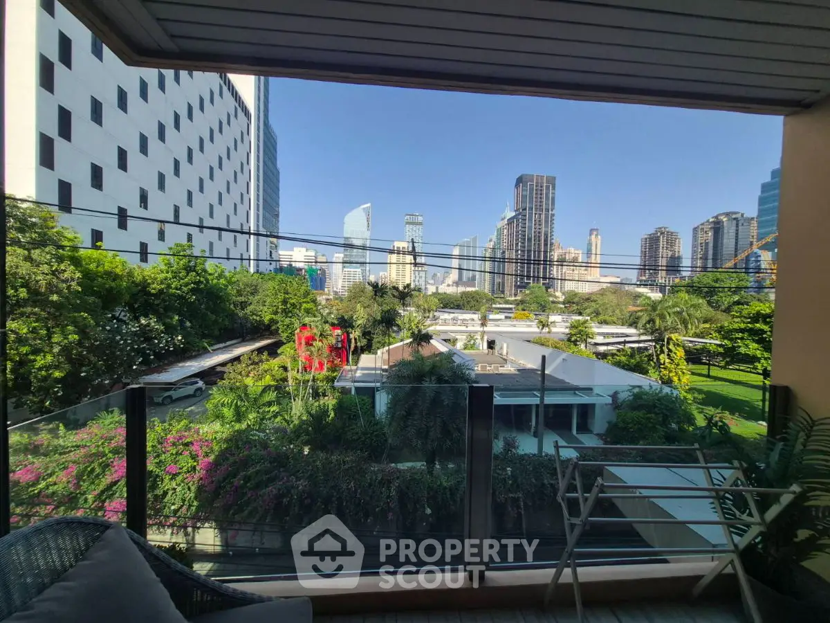 Stunning cityscape view from a modern balcony with lush greenery and skyline.