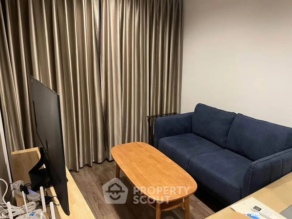 Cozy living room with blue sofa and wooden coffee table, perfect for relaxation.