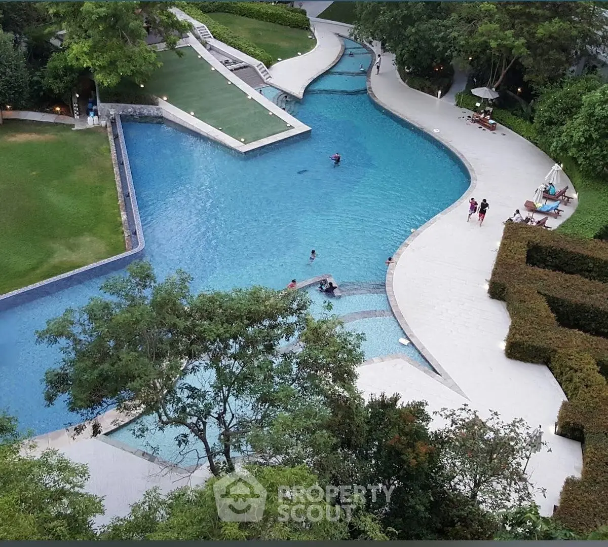 Luxurious residential pool area with lush greenery and modern design, perfect for relaxation and leisure.