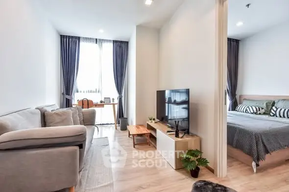 Modern living room with cozy sofa and TV, adjacent to stylish bedroom with natural light.