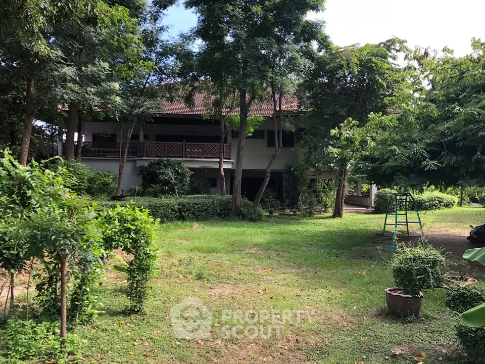 Charming two-story house with lush garden and mature trees, perfect for nature lovers.