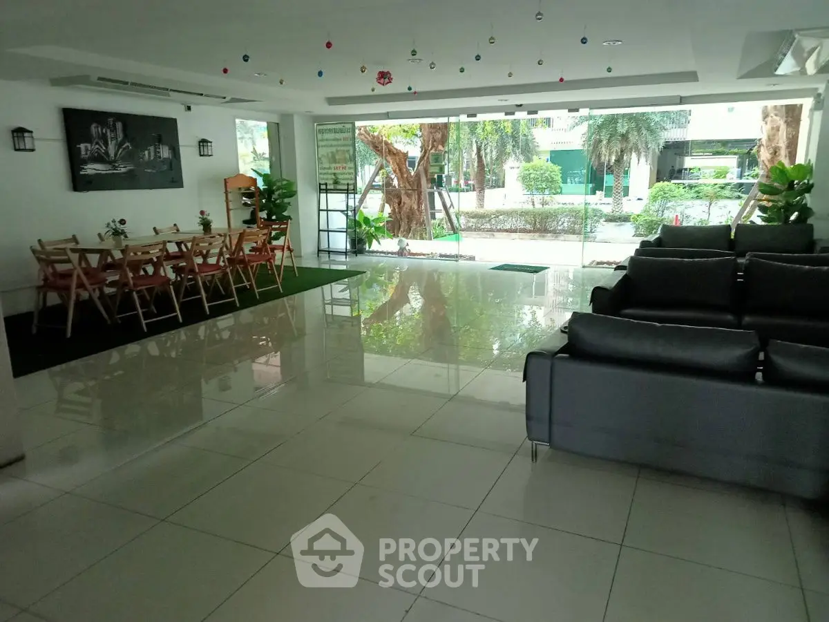 Spacious living area with modern decor and garden view, perfect for gatherings and relaxation.